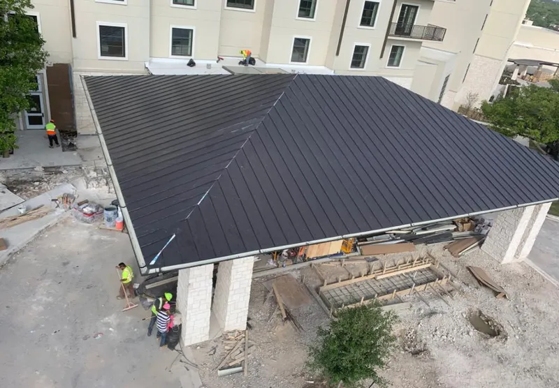 Metal roofing installation team working on a commercial building in Baytown